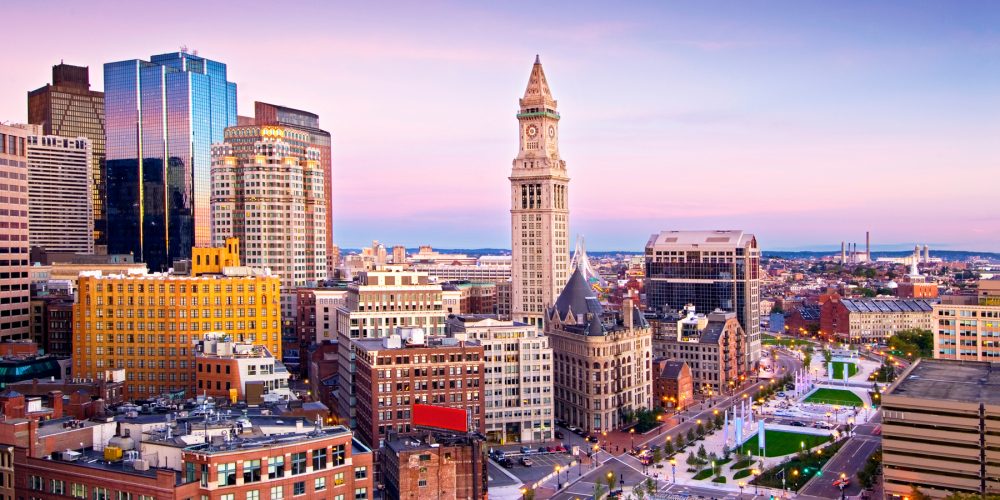 The historic buildings of the Custom House District and modern skyscrapers of downtown Boston rise above the Rose Fitzgerald Kennedy Greenway, a linear park on the waterfront.